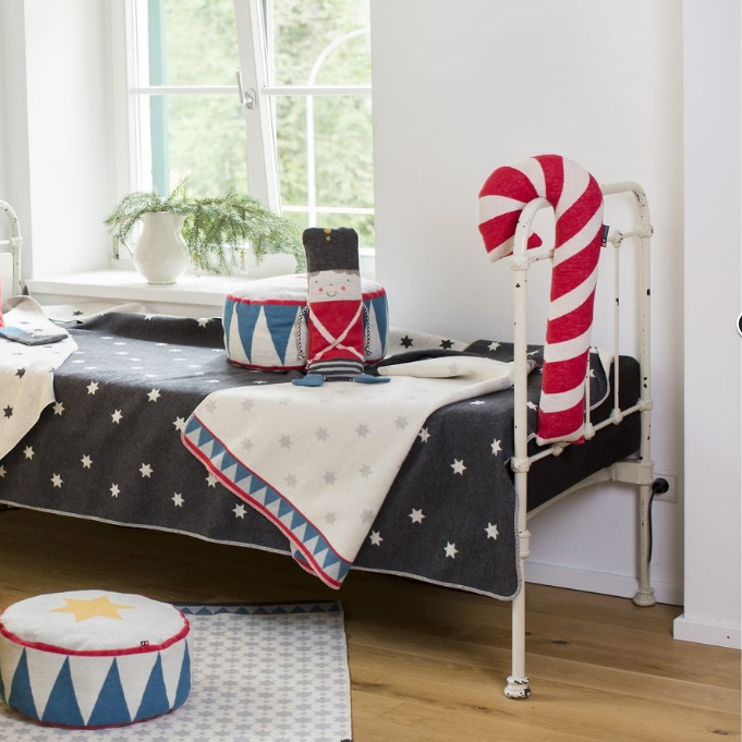 Unique nutcracker-themed blanket draped on metal bed with festive cushions, perfect for individual style and home decor. - JUWEL Decke in der Puppe Zinnsoldat