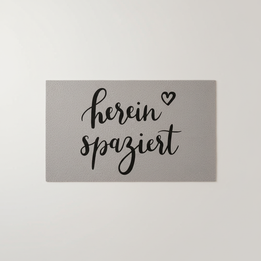 Gray washable doormat with black "herein spaziert" script and heart, unique home decor, individual style. - Waschbare Fußmatte Hereinspaziert