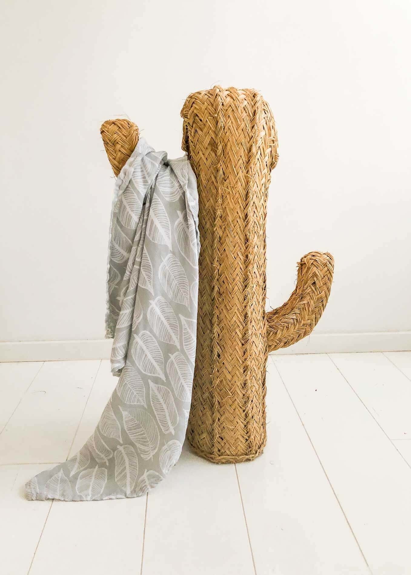Warm grey swaddle draped over a tall woven cactus-shaped wicker decor, showcasing einzigartig Wohndeko and individueller. - Swaddle 120x120 Beleaf Warm grey